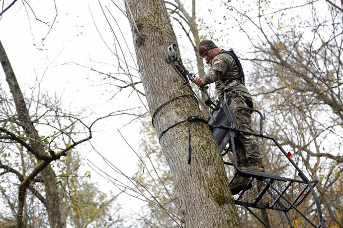 hunter taking position on tree stand
